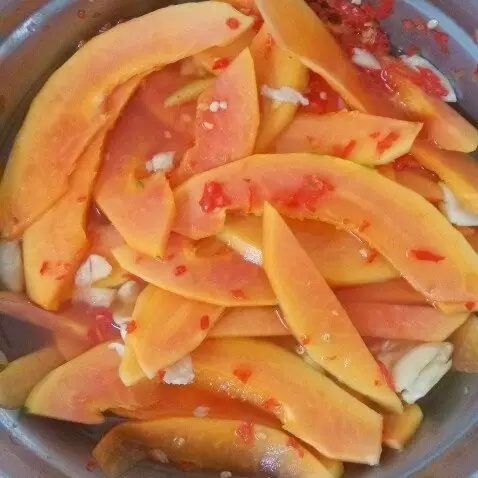 將酸木瓜洗凈去皮，對半切開，切成等份長條，再切成3—4毫米厚的小片，加適量的鹽，攪拌使木瓜片與鹽充分融合，腌一個小時。將盆里腌制出來的鹽水倒掉，放入適量的白糖、香醋，放點(diǎn)辣椒醬，攪拌均勻，放置2小時左右就可以吃了。