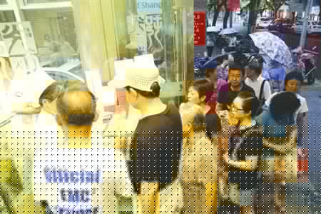 昨天申城依舊悶熱，不少市民在光明邨門前苦苦等待，只為新鮮出爐的鮮肉月餅。